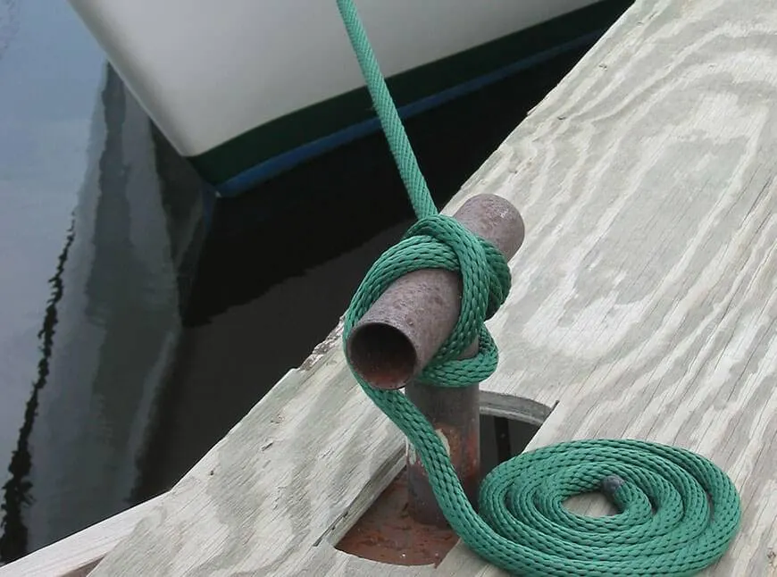Green Soft Lines dock line tied to a dock cleat beside a boat hull
